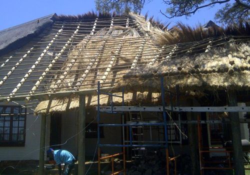 Thatch roof extension under construction on a scaffold